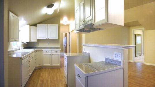 The new kitchen featured white cabinets and appliances and granite countertops